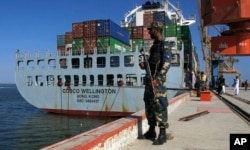 FILE - A Pakistan Navy soldier stands guard while a loaded Chinese ship is readied for departure at Gwadar port, Nov. 13, 2016.