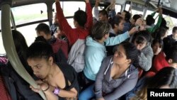 FILE - Passengers ride a Transmilenio system bus during rush hour in Bogota, October 27, 2014.