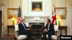 El primer ministro británico David Cameron, derecha, da la bienvenida al secretario de Estado de EE.UU., John Kerry, el lunes 25 de febrero en Londres. 