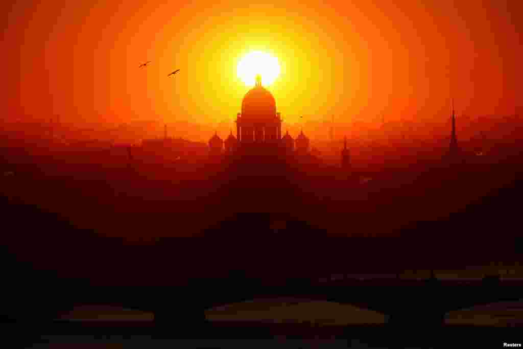 The sun sets behind Saint Isaac’s Cathedral in Saint Petersburg, Russia.