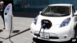 FILE - А Nissan Leaf is getting a quick charge by a solar-assisted EV charging system at Nissan's global headquarters in Yokohama, Japan, July 11, 2015.