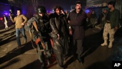 Afghan security forces assist an injured man at the site of an explosion in Kabul, Afghanistan, Jan. 17, 2014. 