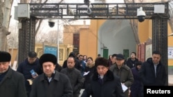 新疆喀什的阿訇2019年1月4日在严密监控下正在离开一所清真寺。