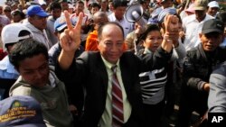 Cambodia’s most prominent human rights defenders Mam Sonando, center, leads a protesters to demand the government to allow him to open a new television channel in front of Ministry of Information, in Phnom Penh, Cambodia, Monday, Jan. 27, 2014. Police in 