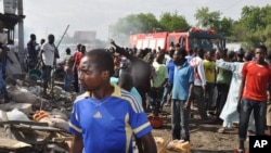 People gather at the scene of a car bomb explosion, at the central market, in Maiduguri, Nigeria, July 1, 2014. They immediately blamed Boko Haram, the Islamic extremist group, whose birthplace is Maiduguri.