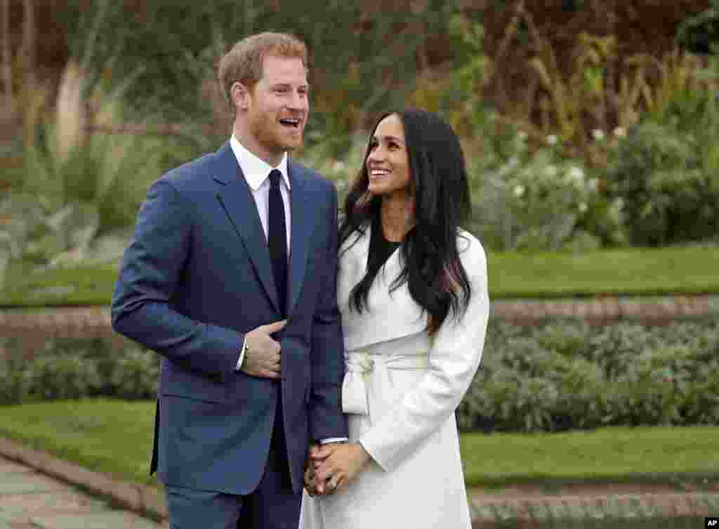 Britain's Prince Harry and his fiancée Meghan Markle pose for photographers during a photocall in the grounds of Kensington Palace in London. Britain's royal palace says Prince Harry and American actress Meghan Markle are engaged and will marry in the spring of 2018.