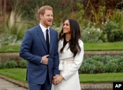 Britain's Prince Harry and his fiancee Meghan Markle pose for photographers during a photocall in the grounds of Kensington Palace in London, Monday Nov. 27, 2017.