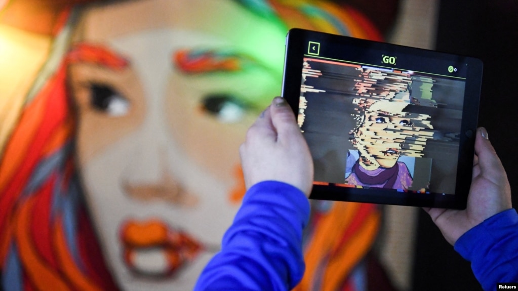 In this file photo, hands holding a tablet computer are pictured during a tour through the urban NFT LAB called "GAME OVER" by the artist group Die Dixons (aka XI DE SIGN) in Berlin, Germany, on October 6, 2021. (REUTERS/Annegret Hilse/File Photo)