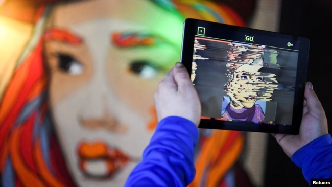 In this file photo, hands holding a tablet computer are pictured during a tour through the urban NFT LAB called "GAME OVER" by the artist group Die Dixons (aka XI DE SIGN) in Berlin, Germany, on October 6, 2021. (REUTERS/Annegret Hilse/File Photo)