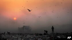 Asap tebal menutupi sinar matahari dekat tempat pembuangan sampah di New Delhi, India (foto: ilustrasi). 