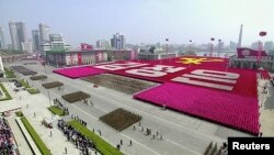 지난해 4월 평양 김일성 광장에서 열린 열병식을 중계한 관영 조선중앙TV 화면. 대규모 인파가 '김정은' 이라는 글자와 노동당 마크를 만들었다.