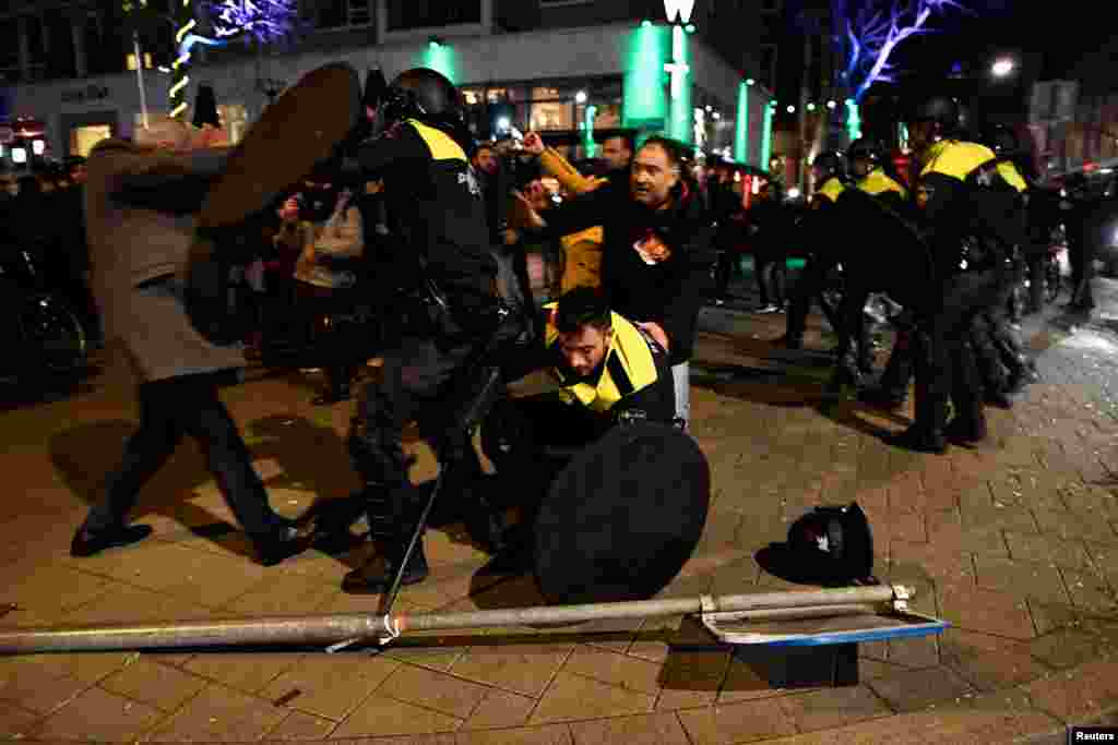 Polisi anti-huru-hara bentrok dengan para demonstran di jalanan dekat konsulat Turki di Rotterdam, Belanda (12/3). (Reuters/Dylan Martinez)