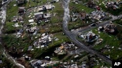 FILE - Destroyed communities are seen in the aftermath of Hurricane Maria in Toa Alta, Puerto Rico, Sept. 28, 2017. Puerto Rico's governor demanded action from U.S. Congress after announcing Feb. 27, 2018, that the Treasury Department has cut a nearly $5 