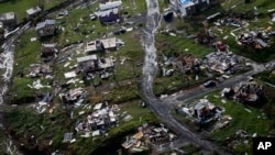 FILE - Destroyed communities are seen in the aftermath of Hurricane Maria in Toa Alta, Puerto Rico, Sept. 28, 2017. Puerto Rico's governor demanded action from U.S. Congress after announcing Feb. 27, 2018, that the Treasury Department has cut a nearly $5 billion disaster relief loan by more than half. 