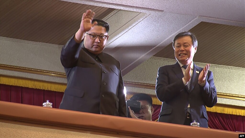 This picture captured from video footage by Korea Pool reporters shows North Korean leader Kim Jong Un (L) and South Korea”s Culture, Sports and Tourism Minister Do Jong-whan (R) during a rare concert by South Korean musicians at the 1,500-seat East Pyongyang Grand Theater in Pyongyang, North Korea, April 1, 2018.