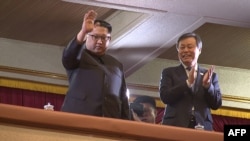 This picture captured from video footage by Korea Pool reporters shows North Korean leader Kim Jong Un (L) and South Korea's Culture, Sports and Tourism Minister Do Jong-whan (R) during a rare concert by South Korean musicians.