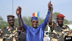 Le président Idriss Déby Itno, au centre, lève les mains des militaires tchadiens revenus du Niger, à N’Djamena, Tchad, 11 décembre 2015.