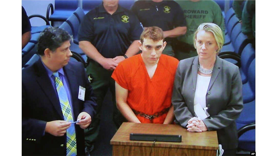 A video monitor shows school shooting suspect Nikolas Cruz, center, making an appearance before Judge Kim Theresa Mollica in Broward County Court in Fort Lauderdale, Florida, Feb. 15, 2018.