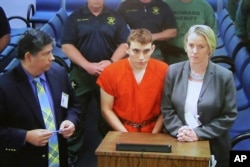 A video monitor shows school shooting suspect Nikolas Cruz, center, making an appearance before Judge Kim Theresa Mollica in Broward County Court in Fort Lauderdale, Florida, Feb. 15, 2018.