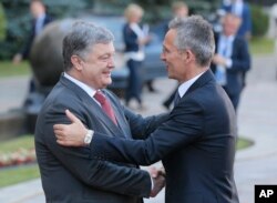 FILE - Ukrainian President Petro Poroshenko, left, and NATO Secretary General Jens Stoltenberg, shake hands during a meeting in Kyiv, Ukraine, July 10, 2017.