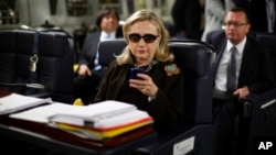 Foto de octubre de 2011 en que se ve a la entonces secretaria de Estado, Hillary Clinton, texteando en su Blackberry.