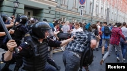 Police officers chase protesters during a rally against planned increases to the nationwide pension age in Moscow, Russia September 9, 2018. REUTERS