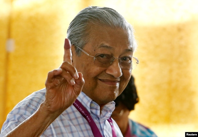 ທ່ານມາຮາເທຍ ໂມຮາມັດ (Mahathir Mohamad) ອະດີດນາຍົກລັດຖະມົນຕີ ຂອງມາເລເຊຍ ແລະ ຜູ້ສະໝັກຝ່າຍຄ້ານ ຈາກພັກປາກາຕັນ ຮາຣາປັນ (Alliance of Hope), ຍົກນິ້ວຊີ້ທີ່ຕິດນ້ຳໝຶກ ໃນຂະນະທີ່ທ່ານໃຊ້ສິດອອກສຽງ ໃນລະຫວ່າງການເລືອກຕັ້ງທົ່ວໄປ ໃນເມືອງ ອາຣໍ ເຊຕາຣ ຂອງມາເລເຊຍ, ວັນທີ 9 ພຶດສະພາ 2018.