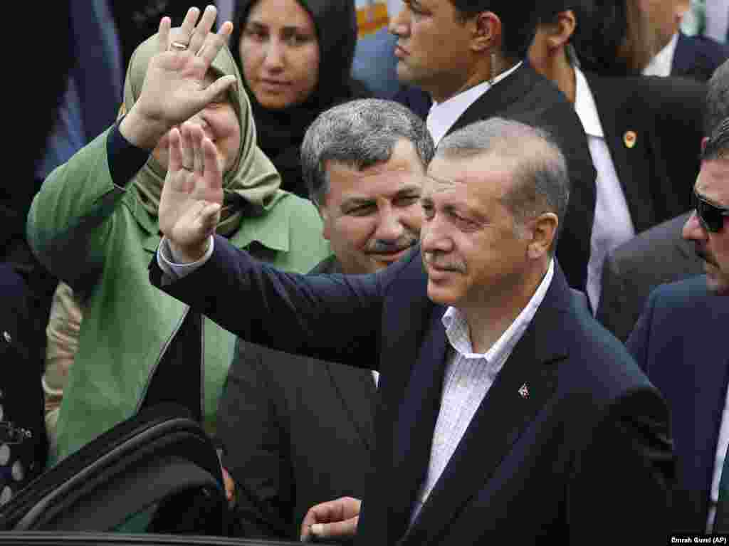 Presiden Turki Recep Tayyip Erdogan melambaikan tangan pada para pendukungnya setelah memberikan suara di sebuah TPS di Istanbul (7/6). (AP/Emrah Gurel)