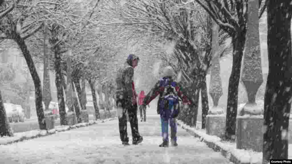 Syrians walk in snow in Al-Ghouta district of Homs, January 9, 2013 (Lens Young Homsi)