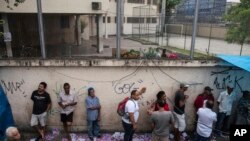 Votantes hacen fila en un centro de votación en la favela Mare en Rio de Janiero el 28 de octubre del 2018,
