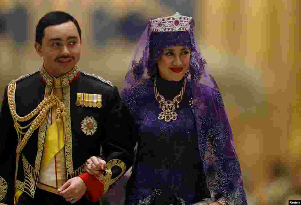 Brunei&#39;s newly-wed royal couple, Prince Abdul Malik and Dayangku Raabi&#39;atul &#39;Adawiyyah Pengiran Haji Bolkiah, leave the royal wedding banquet at the Nurul Iman Palace in Bandar Seri Begawan. Malik is the son of Brunei&#39;s Sultan Hassanal Bolkiah, one of the world&#39;s richest men.