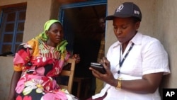 A WFP field monitor assistant conducts a food security survey with a Burundian resident in Bihogo village, using a personal digital assistant (PDA) to collect the data