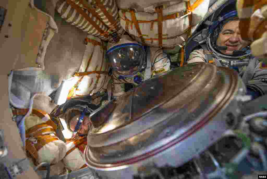 NASA astronaut Jeff Williams, left, Russian cosmonaut Alexey Ovchinin of Roscosmos, center, and Russian cosmonaut Oleg Skripochka of Roscosmos are seen inside the Soyuz TMA-20M spacecraft a few moments after they landed in a remote area near the town of Zhezkazgan, Kazakhstan.