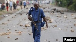 FILE - A policeman holds his rifle during a protest against Burundi President Pierre Nkurunziza in Bujumbura, Burundi, May 20, 2015. 