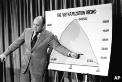 Defense Secretary Melvin R. Laird points to a chart showing the administration's Vietnamization record during a news conference, Oct. 11, 1972, in Washington.