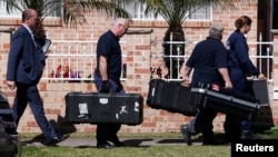 FILE - Members of the Australian Federal Police (AFP) forensic unit carry equipment into a house that was involved in pre-dawn raids in the western Sydney suburb of Guilford, September 18, 2014. 