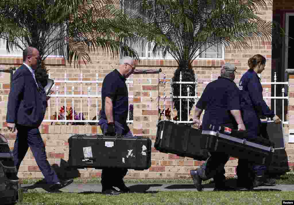 Members of the Australian Federal Police (AFP) forensic unit carry equipment into a house that was involved in pre-dawn raids in the western Sydney suburb of Guilford September 18, 2014. 