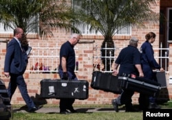 FILE - Members of the Australian Federal Police (AFP) forensic unit carry equipment into a house that was involved in pre-dawn raids in the western Sydney suburb of Guilford, Sept. 18, 2014. Without referring to specifics, Prime Minister Tony Abbott said Australia was at "serious risk from a terrorist attack."