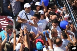 In this photo taken June 20, 2017, Lulzim Basha, leader of the Democratic Party (PD), flashes victory sign at his supporters at an electoral rally in the town of Kavaja, Albania.