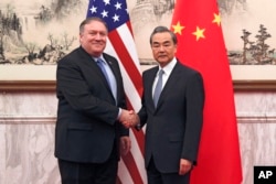 El secretario de Estado de EE.UU., Mike Pompeo, (izquierda) estrecha la mano de ministro de Relaciones Exteriores chino, Wang Yi, antes de su reunión en Beijing, China, el lunes, 8 de octubre de 2018.