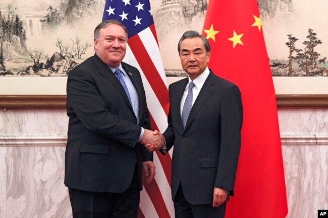 El secretario de Estado de EE.UU., Mike Pompeo, (izquierda) estrecha la mano de ministro de Relaciones Exteriores chino, Wang Yi, antes de su reunión en Beijing, China, el lunes, 8 de octubre de 2018.