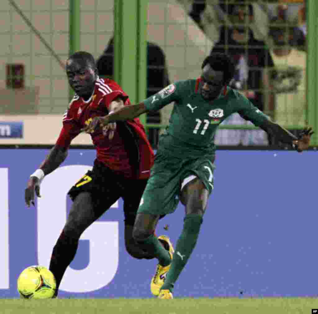 Jonathan Pitroipa, do Burkina Fasso, disputa a bola com Mateus Galiano, durante o primeiro jogo das Palancas Negras, no CAN 2012, no Estádio de Malabo, a 22 de Janeiro