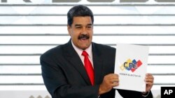 El presidente de Venezuela, Nicolás Maduro, sostiene el certificado del Consejo Nacional Electoral que lo declara ganador de las elecciones presidenciales, durante una ceremonia en la sede del CNE en Caracas, Venezuela.