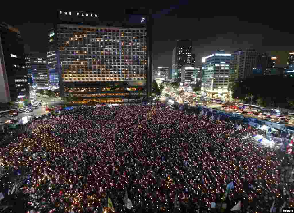 South Koreans take part in a candlelight demonstration demanding resignation of President Park Geun-Hye and calling for reform of national spy agency in central Seoul. 