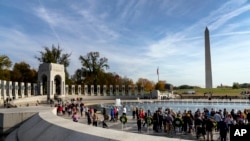 Friends, family, and guests greet World War II veterans following a Veterans Day ceremony at the World War II Memorial in Washington, Nov. 11, 2021.
