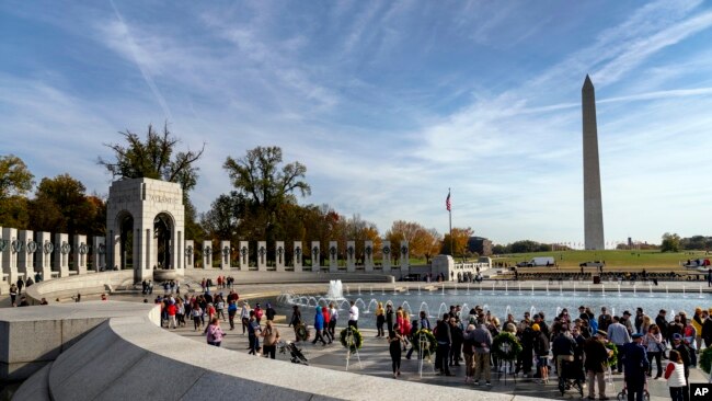 Friends, family, and guests greet World War II veterans following a Veterans Day ceremony at the World War II Memorial in Washington, Nov. 11, 2021.