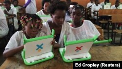 Crianças exploram pequenos computadores portáteis na escola da missão católica Dom Bosco no Sambizanga, Luanda. Angola