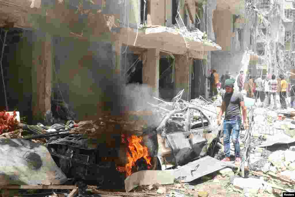 People inspect the damage at a site hit by airstrikes in the rebel-held area of Aleppo&#39;s Bustan al-Qasr, April 28, 2016.