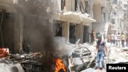 Các tòa nhà bốc cháy sau các vụ không kích ở Bustan al-Qasr, Syria, ngày 28/4/2016. 