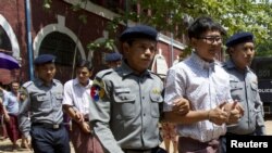 Detained Reuters journalist Kyaw Soe Oo and Wa Lone are escorted by police as they leave after a court hearing in Yangon, Myanmar, August 20, 2018.